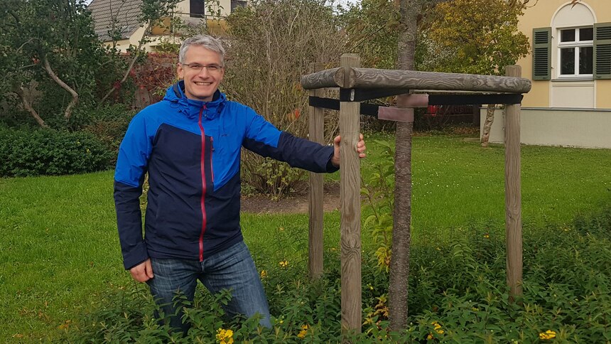 Mann neben Obstbaum