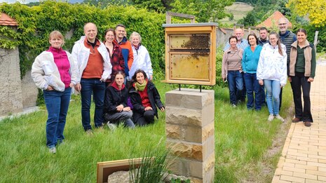 Gruppe von Imkern hinter einer Schaubeute