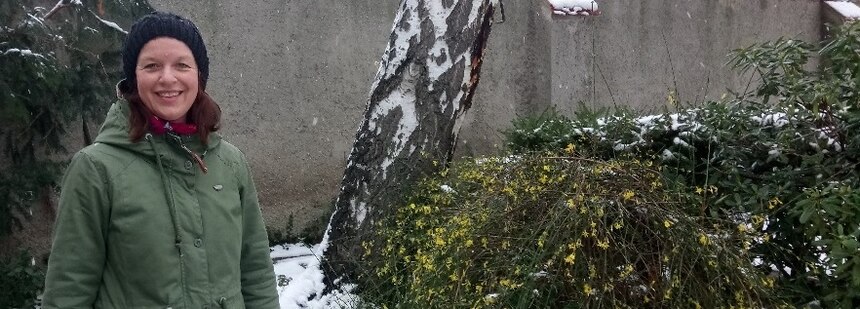 Frau vor blühendem Winterjasmin